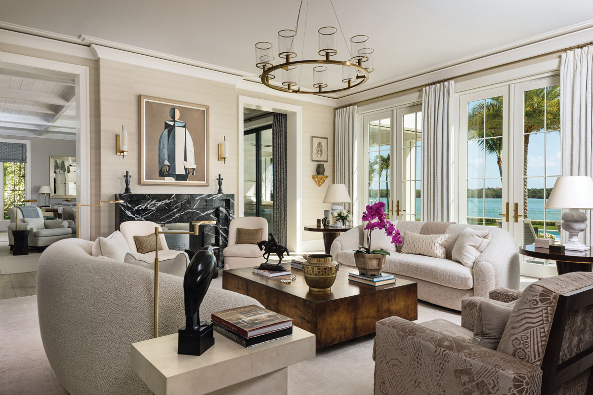 Inspired by the midcentury modern “Polar Bear” sofa, Karen Melk collaborated directly with custom furniture designer James Michael Howard to appoint the living room. Dressing the wall above an exquisite, black Nero Marquina fireplace, the authentic Harlequin by artist Duilio Barnabe sets the tone for the interior palette.