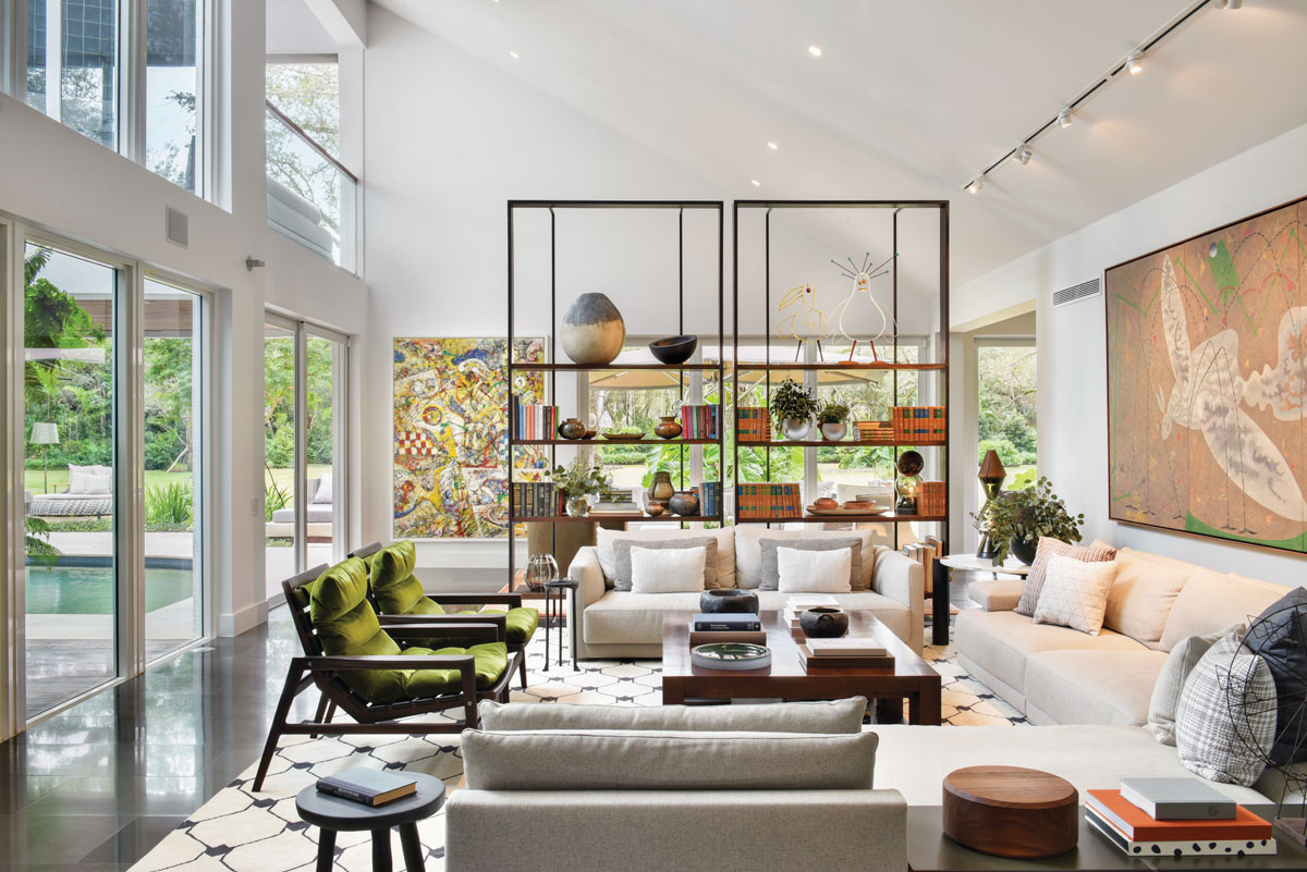 A massive metal étagère by Baxter stands up to the double height ceiling and serves as a screen that creates an intimate corner, but retains the views.