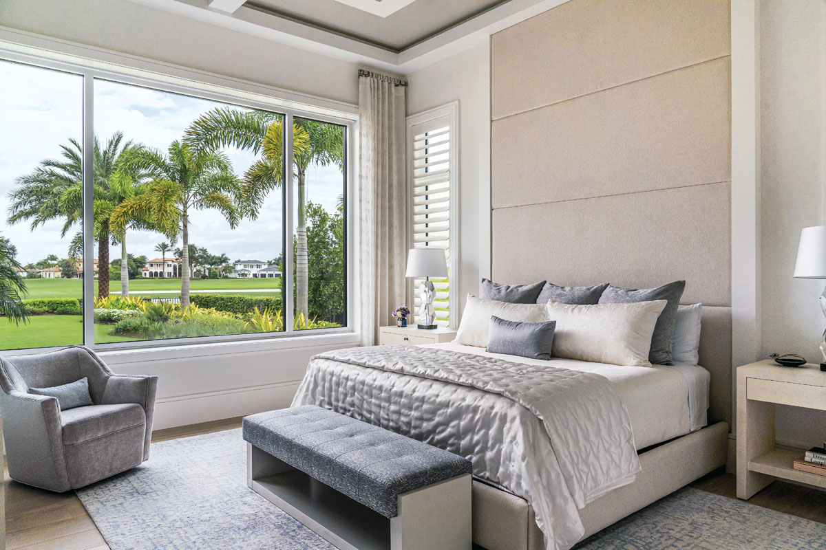 The main guest suite is awash in neutral hues and silky fabrics, providing a pleasing retreat with a sweeping backyard view.