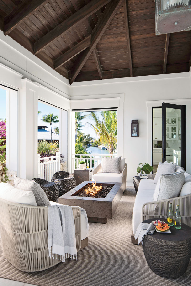 An outdoor living room reveals furniture from Restoration Hardware, with the exception of the wicker stools by Palecek. A stained cypress ceiling crowns the space.
