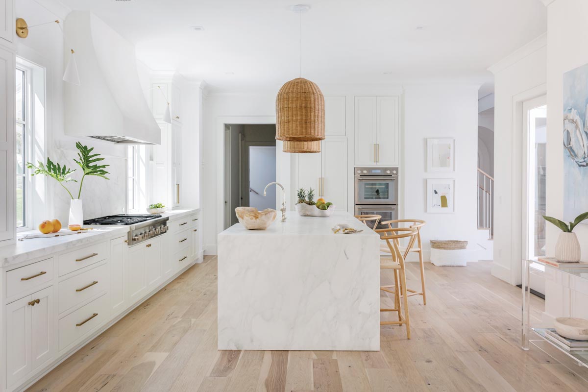 Dennis chose Calacatta Caldia marble for the kitchen surfaces and had fabricators create an integrated sink into the island. The flooring is whitewashed oak.