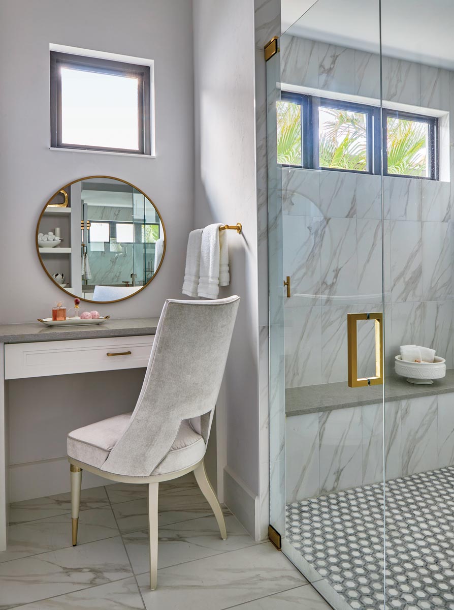 An elegant vanity chair by Caracole was upholstered in a high-performance fabric to withstand the humidity in the primary bathroom.