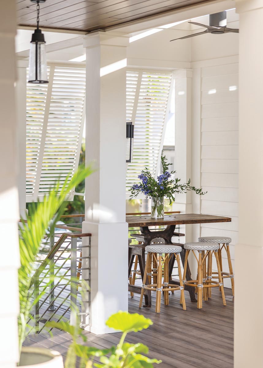 Bahama shutters in this outdoor nook prevent glare from the morning and midday sun while allowing sea breezes and beautifully filtered natural light. The owners relocated the table from their Atlanta home’s screened porch. The base was rescued from an old Tennessee factory, and the vendor added a reclaimed-wood surface.