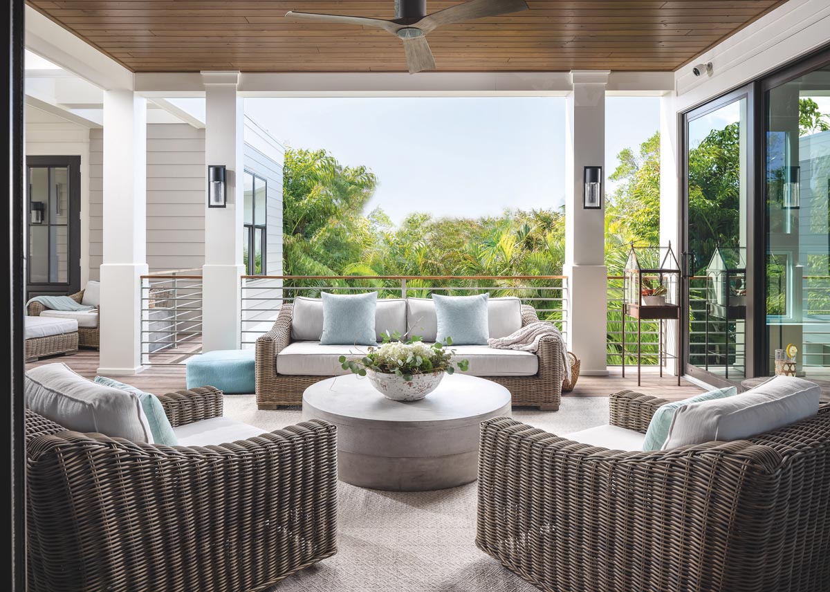 Family and guests gravitate to this breezy alfresco family room to enjoy morning coffee. Anchored by a Dash & Albert rug, modern RH furnishings blend effortlessly with antique accent tables.