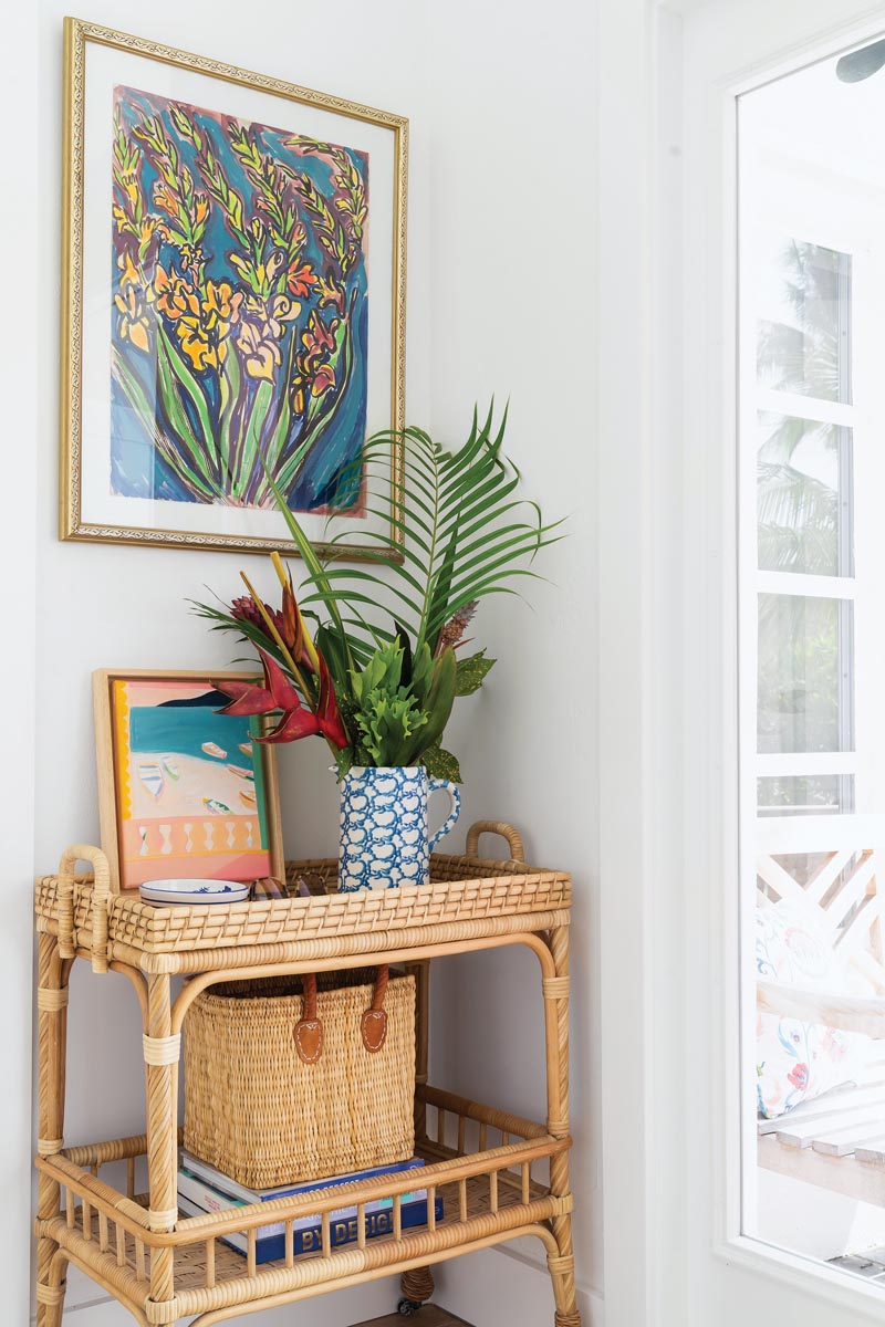 In this photo-ready corner, a wicker cart anchors colorful art and tropical foliage.