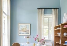 Anthropologie’s chic desk and task chair give this dreamy, light-filled home office a bespoke feel. A woven chair from Lulu and Georgia creates a textural accent, while Crate & Barrel cabinets display art books and collectibles. Pansy Bayou Design Atelier’s colorful flatweave rug reinforces the wall’s watery green-blue hue.