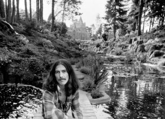 George Harrison by a creek at his Friar Park estate in a 1974 photograph by Terry O’Neill. Note the property’s mansion in the background.