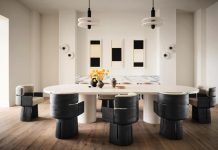 “The goal for the dining room was high sophistication, which we accomplished by blending rich textures,” says Magel. “The Richard Sierra artwork served as a striking backdrop while the clients’ love for black guided the palette, ensuring a refined yet personal space.” The custom marble table is surrounded by chairs from The Invisible Collection. The hanging pendants and wall sconces are both by Apparatus Studio.