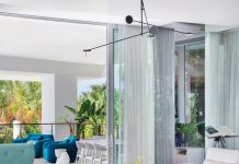 In the living room, the three-part asymmetrical coffee table inspired designer Luciana Bueno to choose a light fixture by Bover that features movable arms