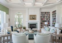 Marco Island Home Exudes Gulf Grandeur In the great room, a row of sliding glass doors gives way to a veranda with sweeping views of the pool and the beach. At one end, a pair of 8-foot custom bookcases showcases the couple’s prized book collection, while window treatments in green fabric delicately frame the unobstructed views. According to the designers, the focal wall was designed around the tones and scale of the artwork hanging above the fireplace.