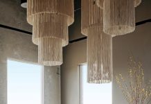 Design Selective at Andros Home Selections in this living room setting include the Kate chandelier by M2C Studio, the Saint-Germain sofa by Poliform, and an area rug by Amadi Carpets. The console, coffee table, and stool are by Verellen