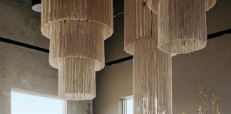 Selections in this living room setting include the Kate chandelier by M2C Studio, the Saint-Germain sofa by Poliform, and an area rug by Amadi Carpets. The console, coffee table, and stool are by Verellen