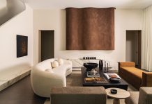 Modern Fort Lauderdale Home is Neutral Territory In a completely renovated and expanded Fort Lauderdale home, the focal point of the modern living room is a fireplace that combines a linear marble base with an asymmetrical decorative sculpture finished in a leather-like Roman clay by Portola Paint. The rich, yet neutral color palette continues in the furnishings with a custom-designed, curvy bouclé sofa offsetting the more linear RH bench and Maiden Home chairs.