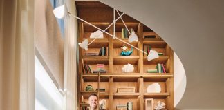Designers Ruben and Katie Gutierrez in the living room of their client Lisa Richberg’s Coconut Grove home. “The double-height bookcase is the centerpiece of the space,” says Ruben. “We chose a rich tone of walnut to contrast the white oak floors. The library ladder adds a playful touch.”