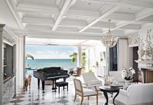 Key Largo Home is a Refined Seaside Dream Intricately coffered ceilings and black and white floors from Devon Tile & Design Studio clad the living room in quiet grandeur, artfully framing the seascape. A high-lacquered, custom Chippendale-style bar with mirrored panels subtly reflects the sea and sky, and the ocean-facing grand piano embodies the sheer splendor of the space.