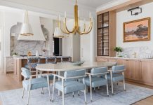 A focus of the dining room is the wet bar. “The warmth of the white oak, the edge of the steel, and the elegance of the Calacatta marble all come together in an effortless, balanced way,” says Dennis. “One of our favorite details is the custom-shaped backsplash, designed to echo the fluted ceiling above and draw the eye toward the art.”