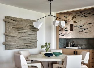 Art by Gwen Hardie and a Sequoia stool-pouf by Fredericia adorn the hallway that leads to the primary bedroom.
