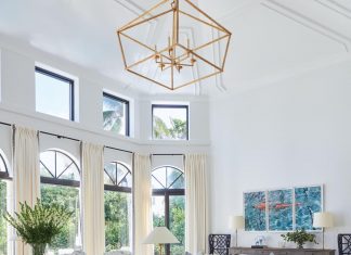 “The living room sits at the center of the home, directly off the foyer, so we wanted it to set the tone for the design,” says designer Ali Frye. “The room was designed specifically for entertaining, so we painted the ceiling white and installed a show-stopping light fixture by Visual Comfort to draw the eye upward.”