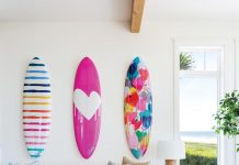 Because the main living area of the home is so large, designer Kate Abt created a couple of sitting nooks for quiet moments. On the wall, colorful surfboards by Kerri Rosenthal reveal the family’s love for the sport.