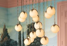The Alesa chandelier by Corey Damen Jenkins for Eichholtz features alabaster orbs on brass strands
